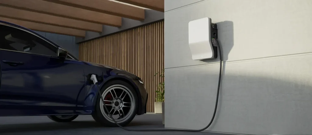 A blue electric car is parked and charging at a wall-mounted charger